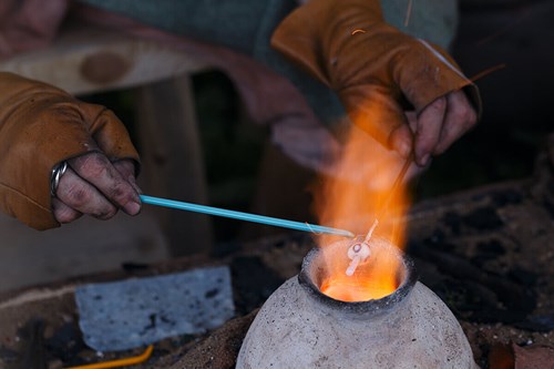 close-up of the hands of a Murano glassmaker working blown glass in a furnace