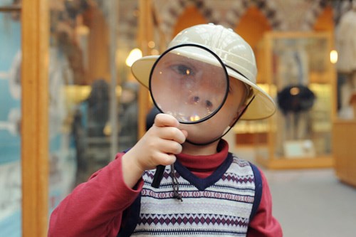 child with magnifying glass in murano glass museum