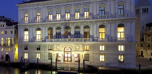 Majestic façade of Palazzo Grassi on the Grand Canal lit up in the evening