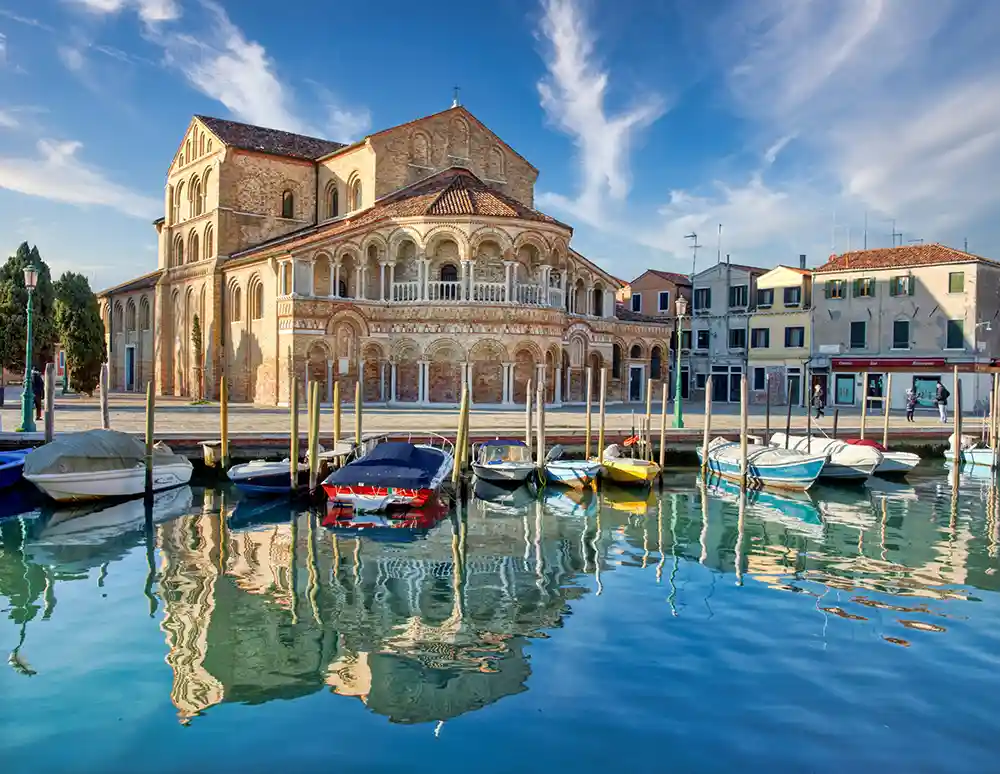 Romanesque facade of the Basilica of Saints Mary and Donatus reflected in Murano’s waters