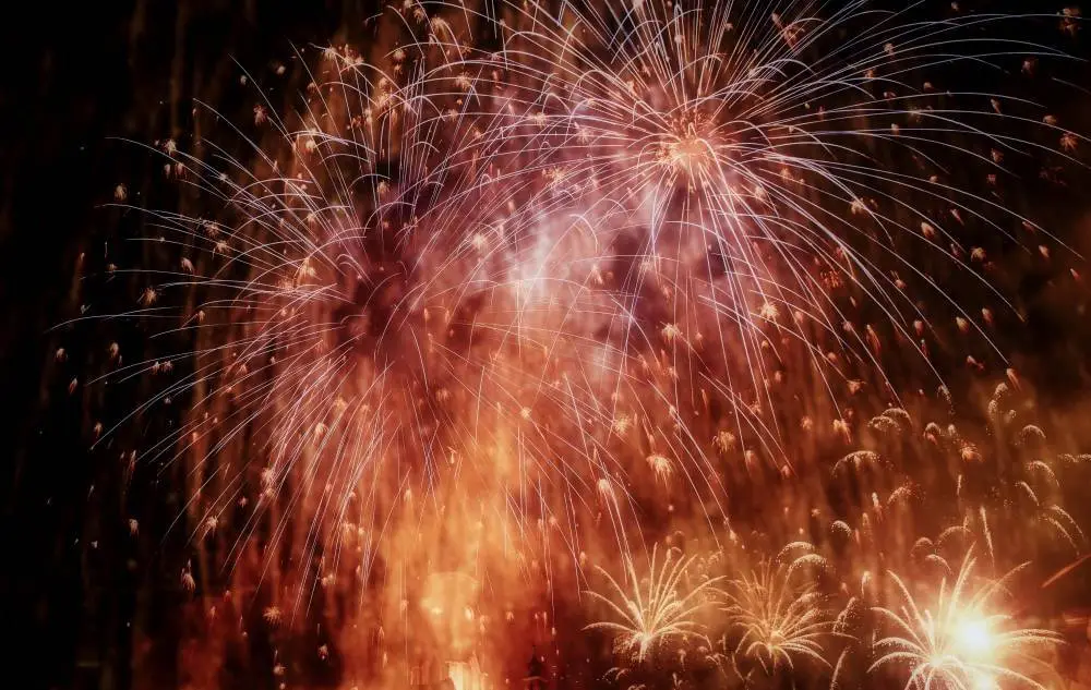 A spectacular display of golden and red fireworks lighting up the night during the Festa del Redentore in Venice.