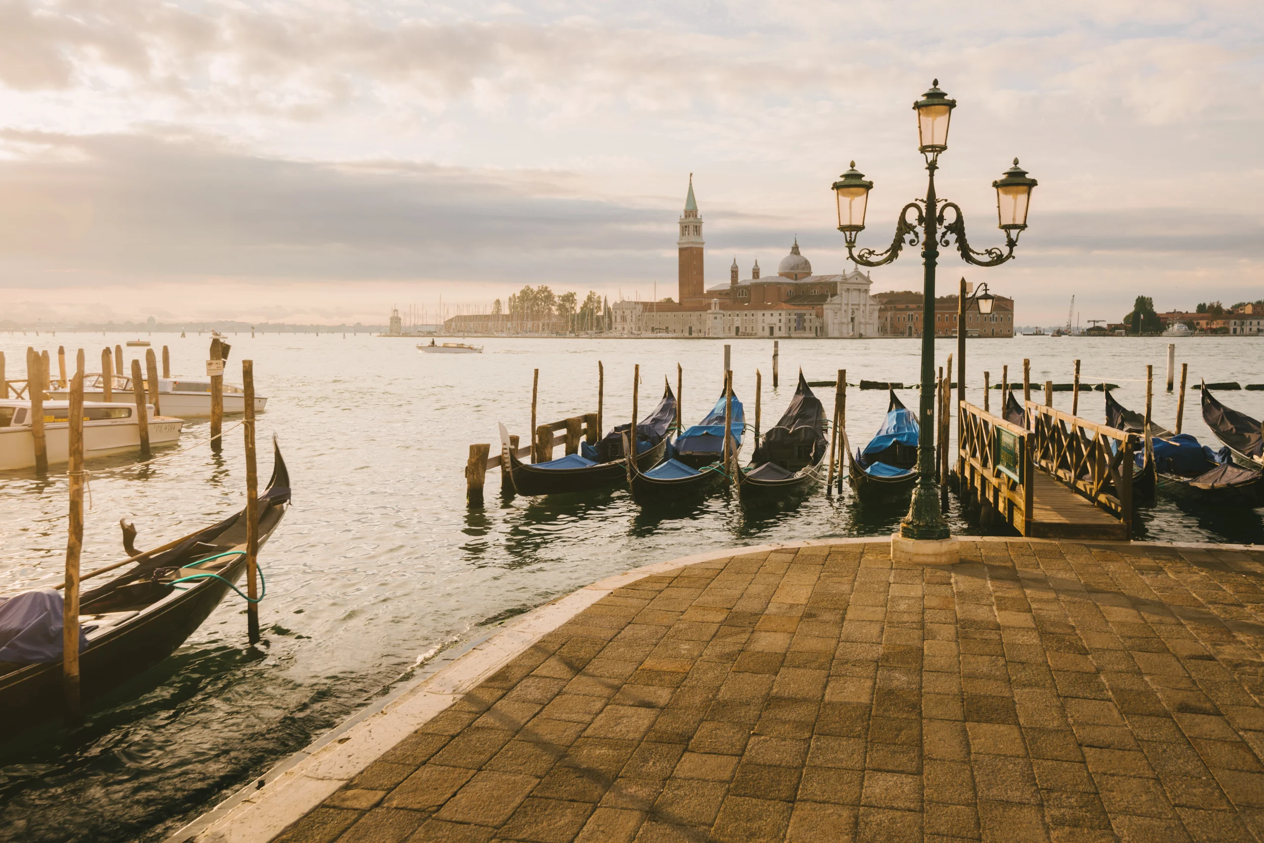 Moored gondolas with a sunset view of San Giorgio Maggiore Island in Venice